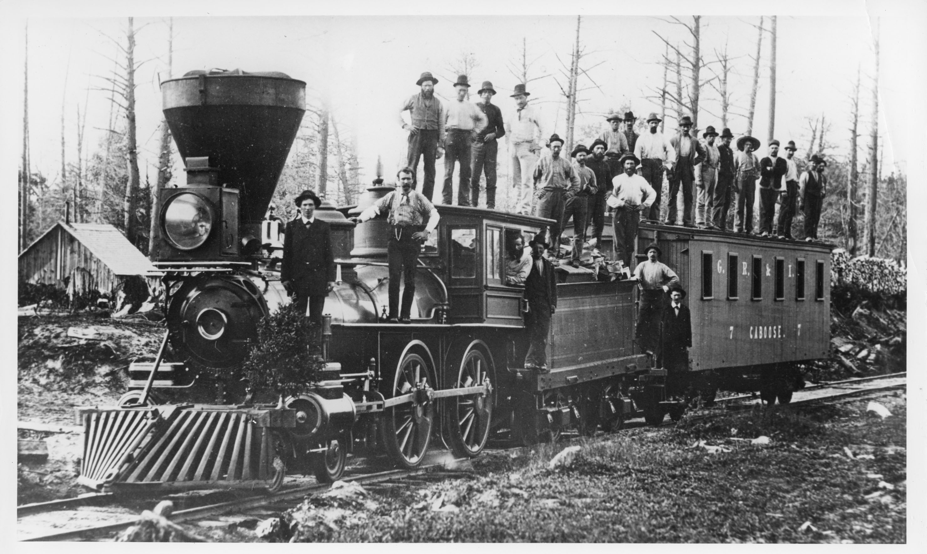 Men stand on top of a Grand Rapids and Indiana locomotive, circa 1875
