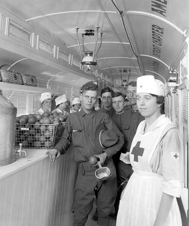 Red Cross nurses and servicemen stand in a railroad car during World War II
