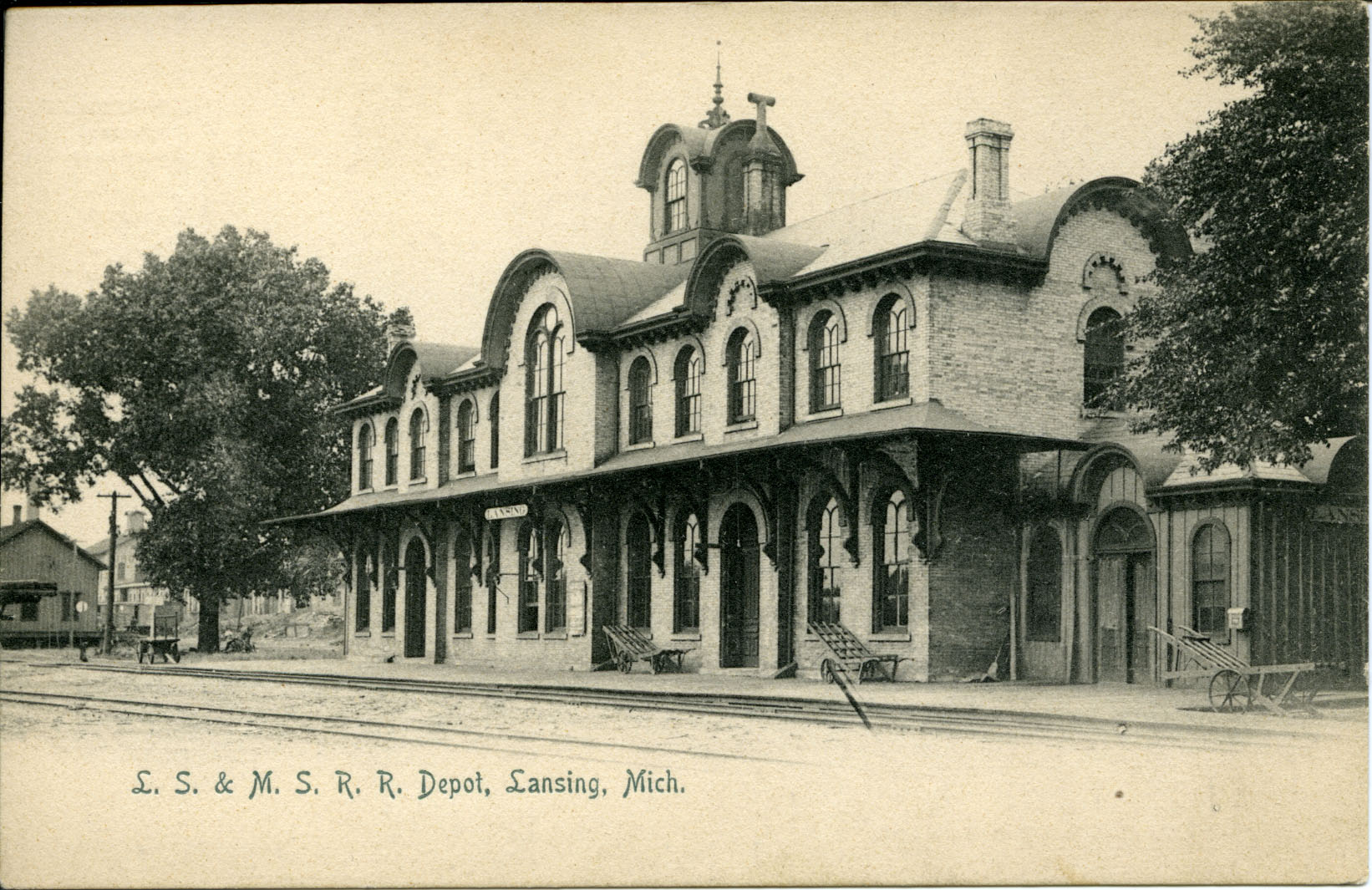 A 19th century depot seen from across a pair of railroad tracks