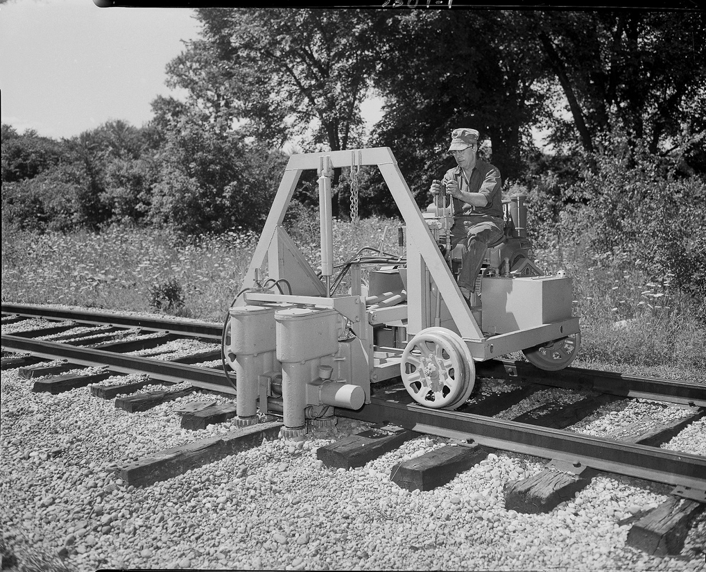 Man using a machine to remove a railroad tie