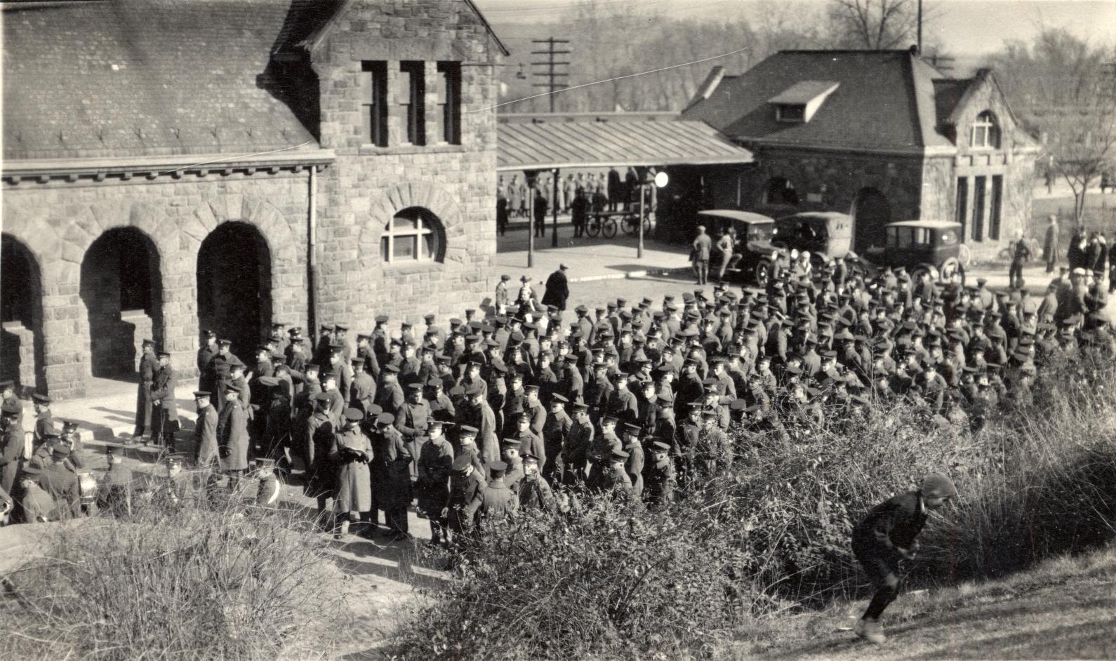 Men in uniform during World War II waiting next to a train in Ann Arbor, Michigan